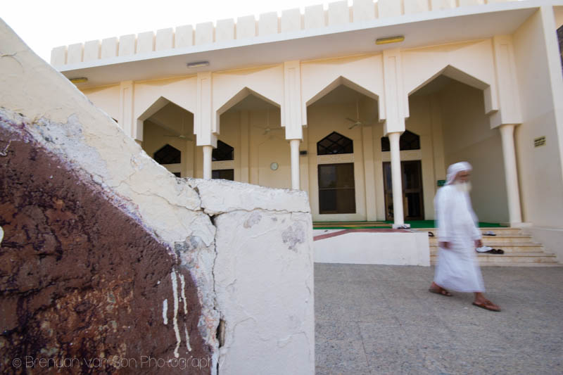 A man walks past a mosque in Oman